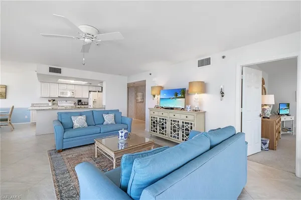 a living room with furniture and kitchen view