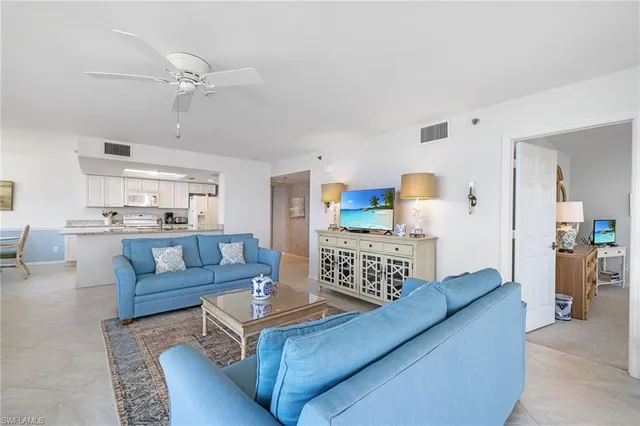 a living room with furniture and kitchen view