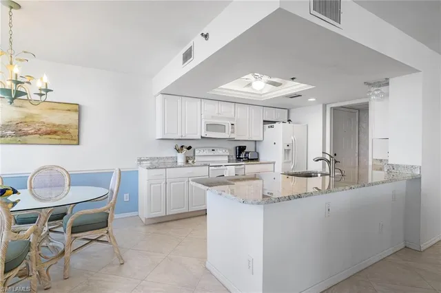 a kitchen with kitchen island granite countertop a sink cabinets and window