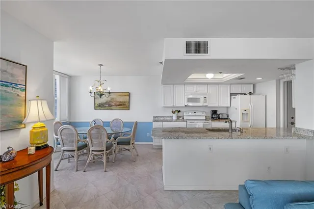 a living room with furniture and kitchen view
