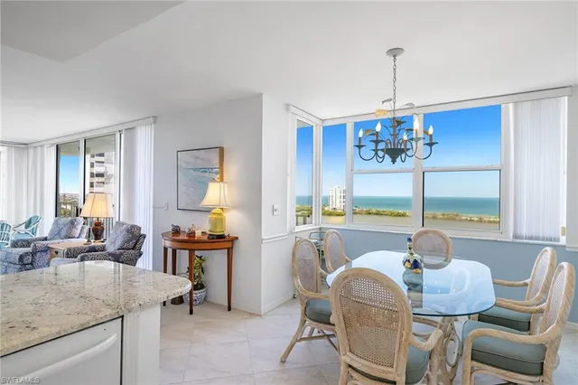 a dining room with furniture a chandelier and window