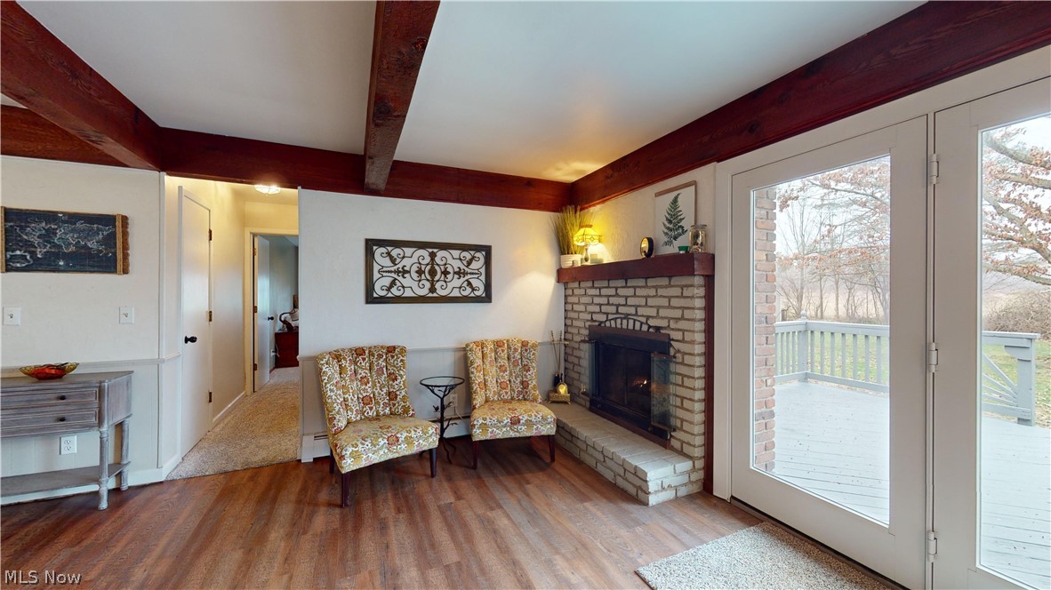 12326 Huntoon Road Painesville, OH 44077 - Photo 22 of 38 Living area featuring a brick fireplace, light hardwood / wood-style flooring, and a healthy amount of sunlight