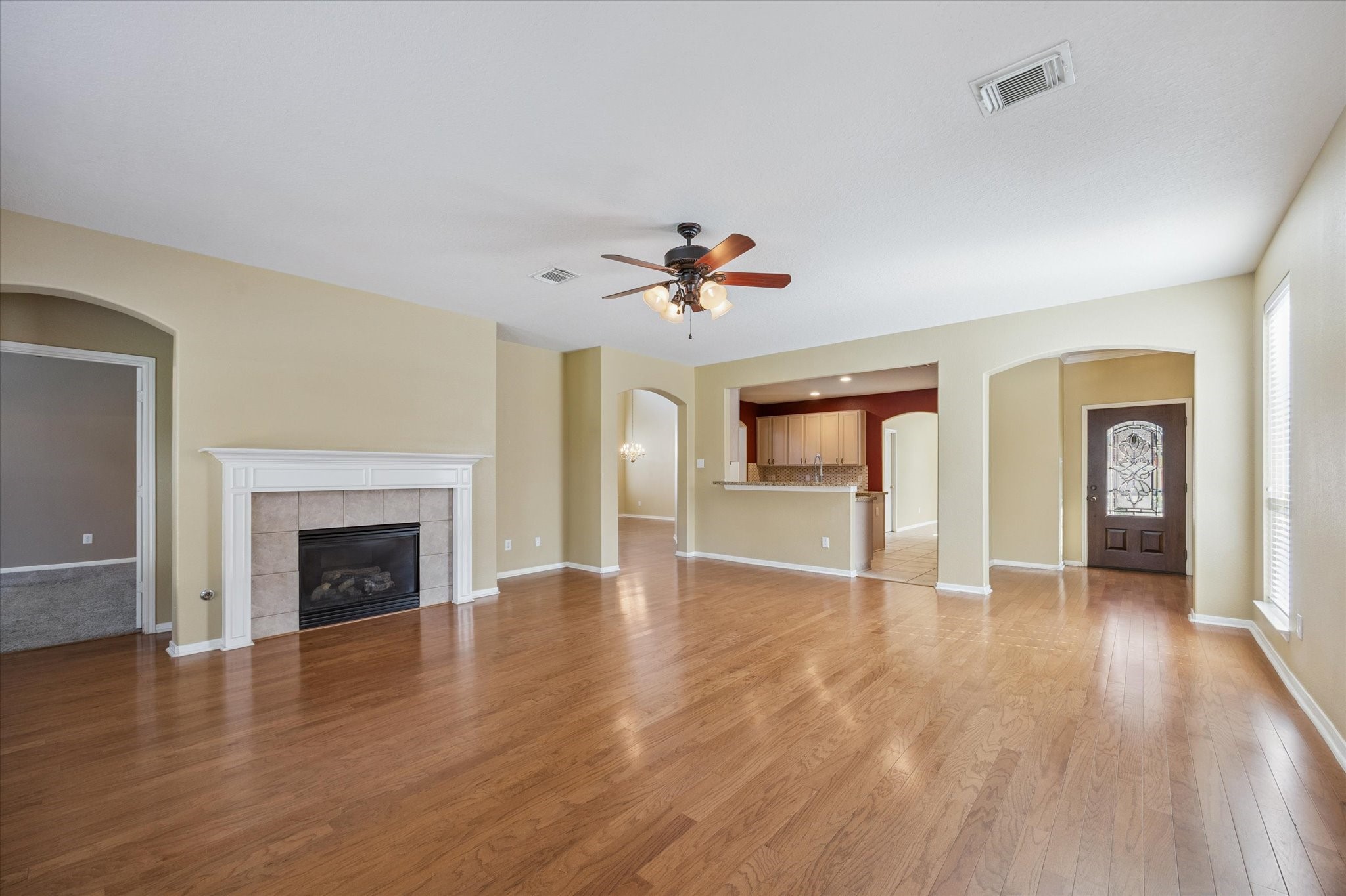 19010 Country Square Drive Houston, TX 77084 - Photo 5 of 23 an empty room with wooden floor fireplace and windows