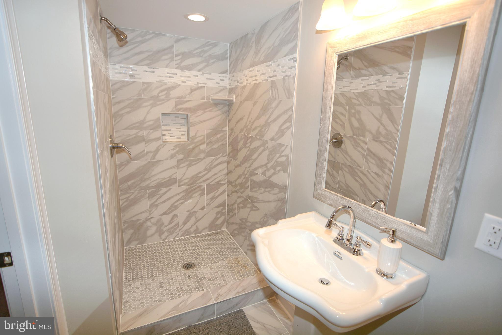 8022 Wallace Road Dundalk, MD 21222 - Photo 22 of 30 a bathroom with a sink a shower and a mirror