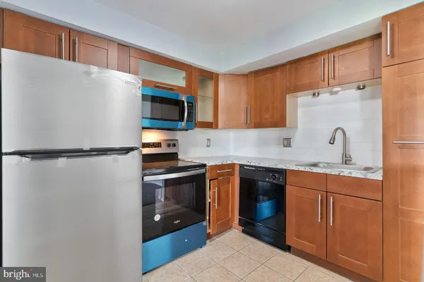 an empty room with a open kitchen and windows