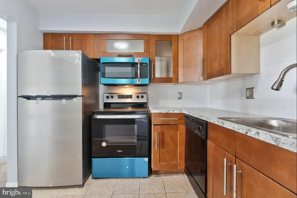 a kitchen with stainless steel appliances granite countertop a refrigerator and a sink
