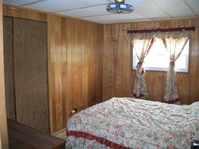 10429 2 Mile Road Thomson, IL 61285 - Photo 11 of 12 a bedroom with a bed and a chandelier