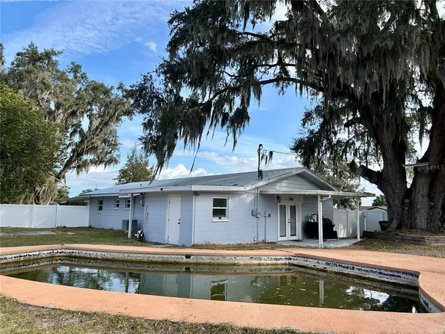 a view of a house with pool and a yard