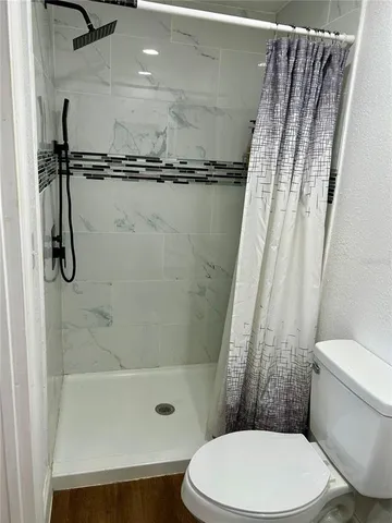 a bathroom with a toilet and a shower