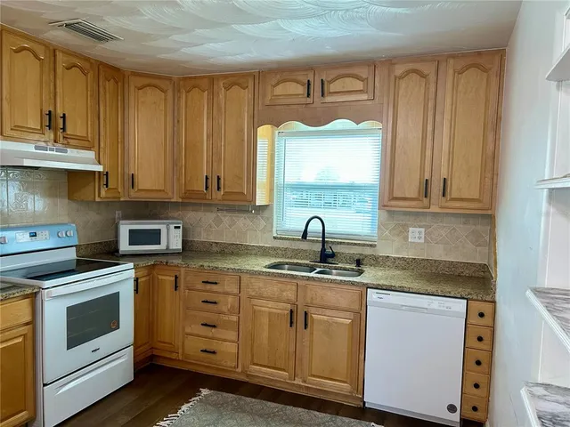a kitchen with stainless steel appliances granite countertop a stove a refrigerator and a microwave