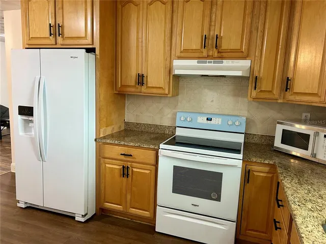 a kitchen with stainless steel appliances white cabinets and a refrigerator