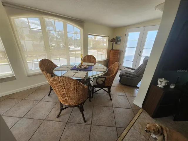 a dining room with furniture and large windows