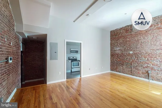 a view of empty room with wooden floor