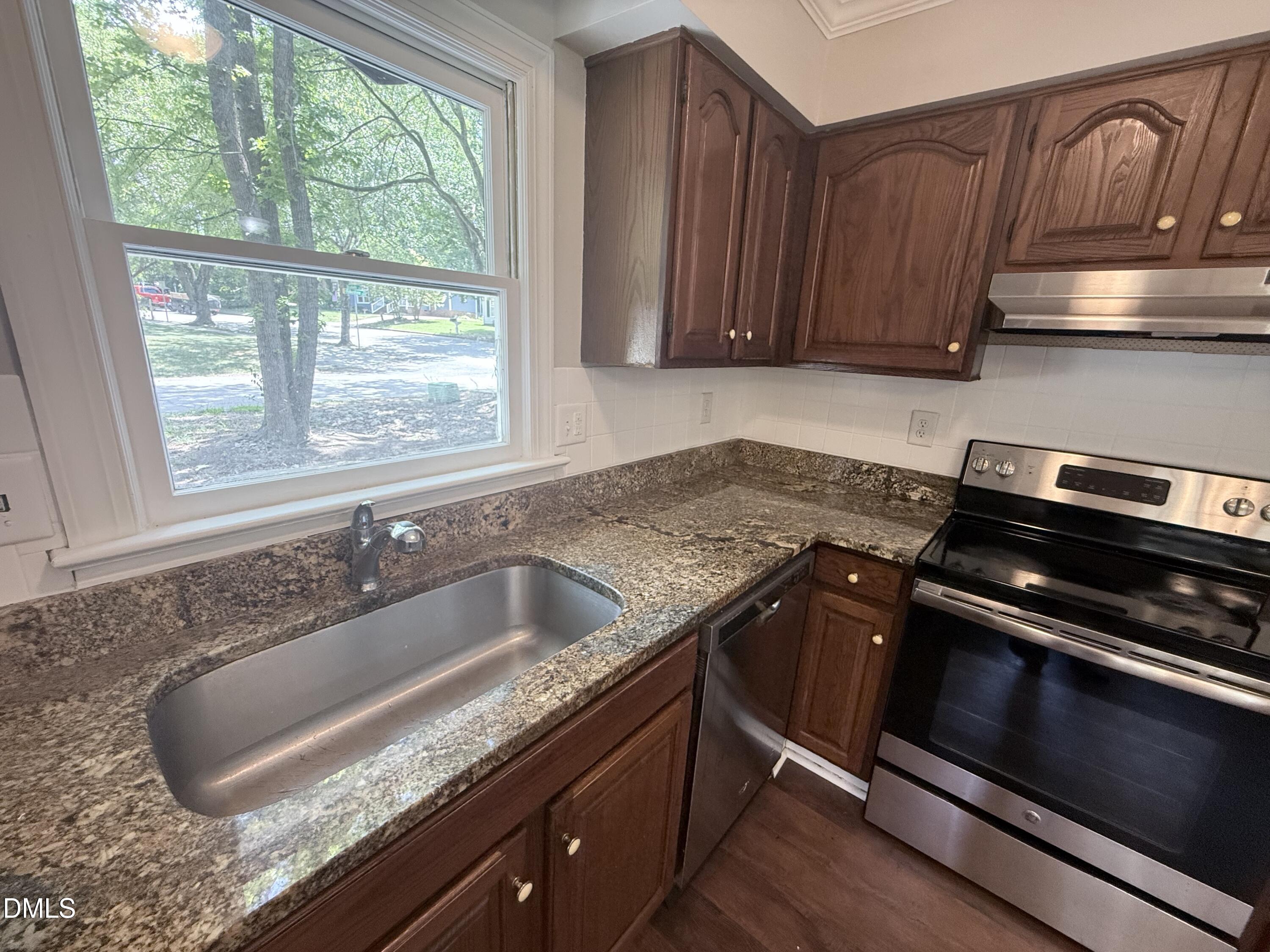 2900 Broadlands Drive Raleigh, NC 27604 - Photo 39 of 60 a kitchen with granite countertop a sink stove and cabinets