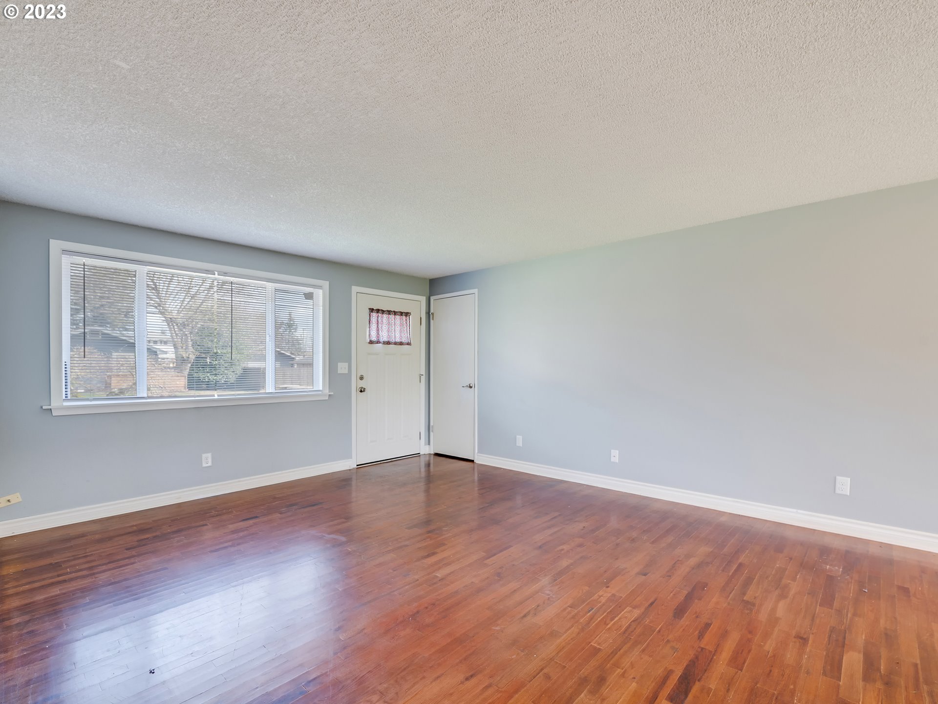 320 36th Street Springfield, OR 97478 - Photo 3 of 26 a view of an empty room with wooden floor and a window