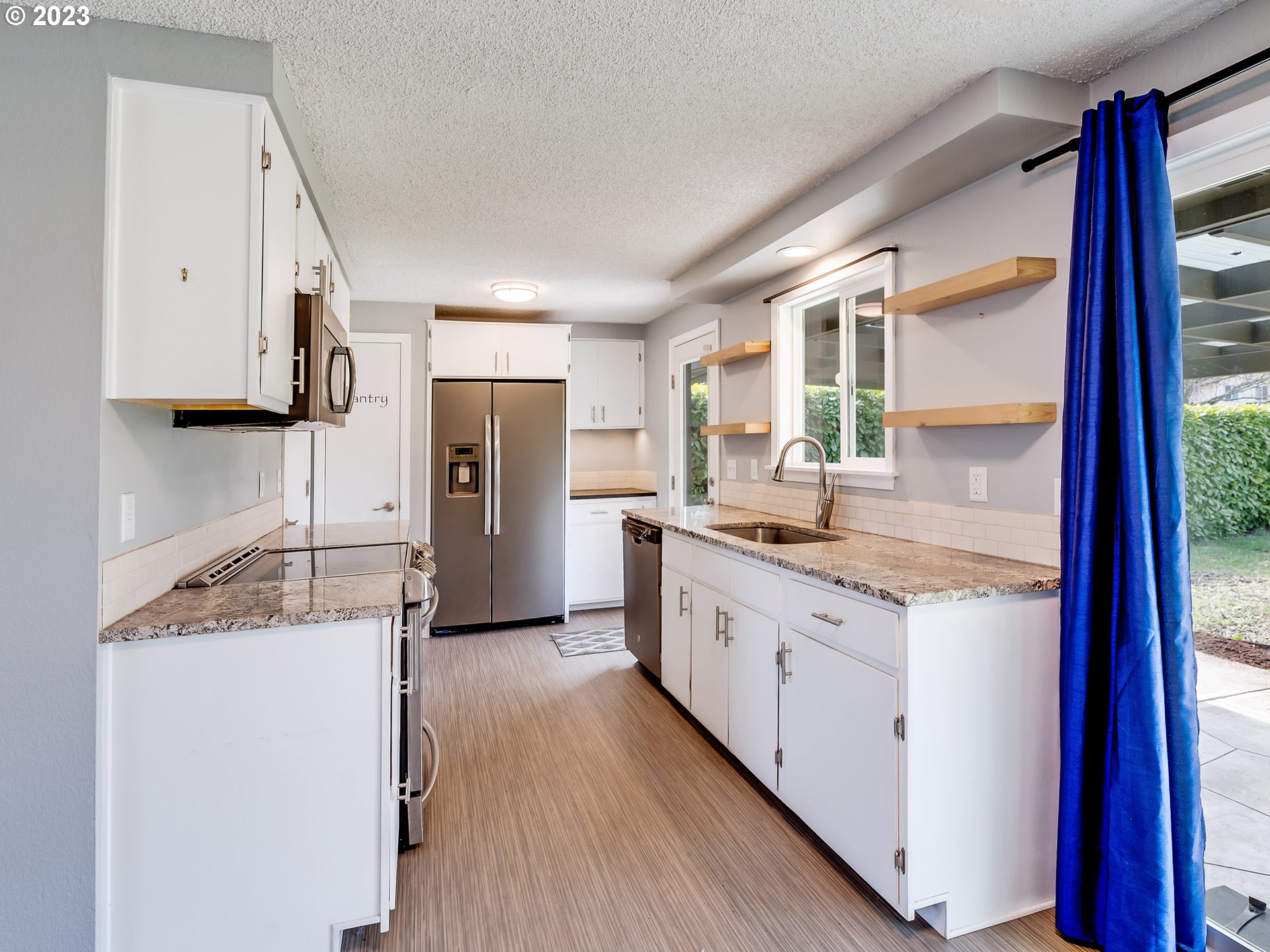 320 36th Street Springfield, OR 97478 - Photo 7 of 26 a kitchen with a refrigerator a sink and wooden cabinets
