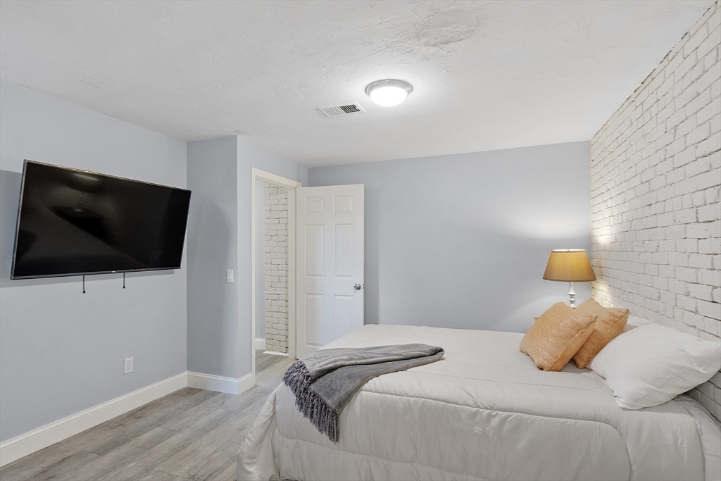 31 Elizabeth Street, Unit G3 Worcester, MA 01605 - Photo 14 of 28 a bedroom with a flat screen tv and a bed