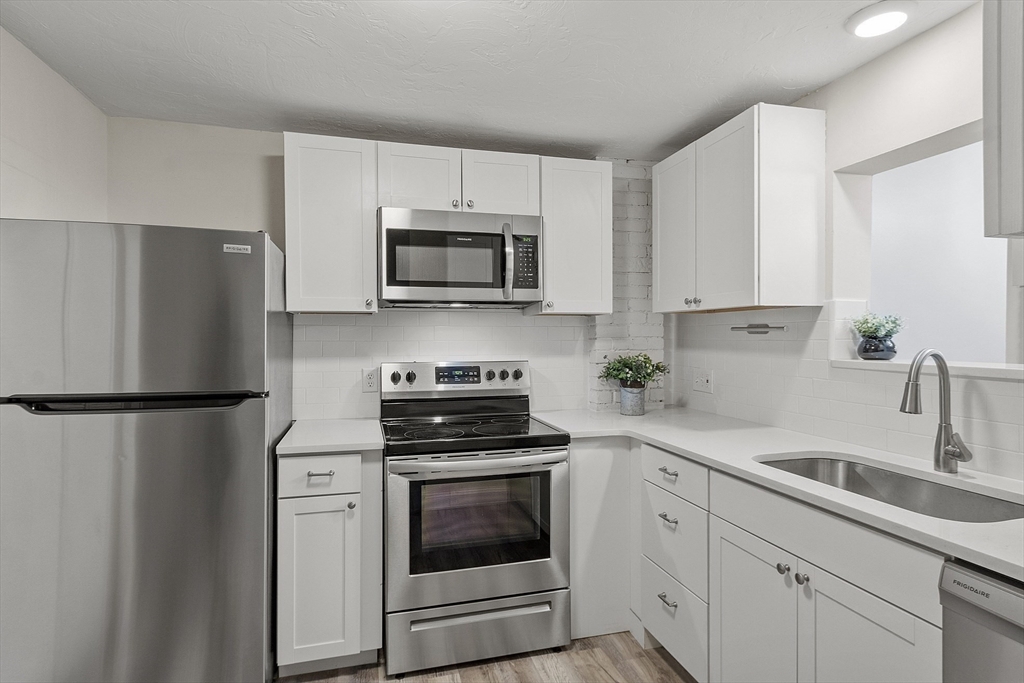 31 Elizabeth Street, Unit G3 Worcester, MA 01605 - Photo 6 of 28 a kitchen with cabinets stainless steel appliances and a sink