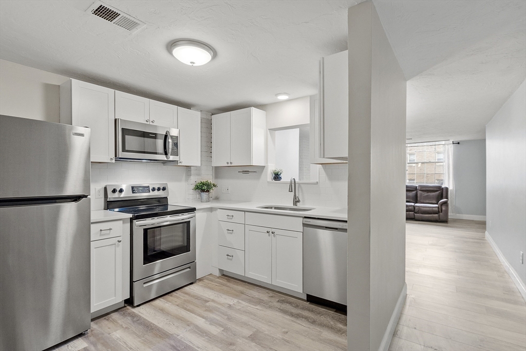 31 Elizabeth Street, Unit G3 Worcester, MA 01605 - Photo 8 of 28 a kitchen with stainless steel appliances granite countertop a stove top oven a sink and a refrigerator
