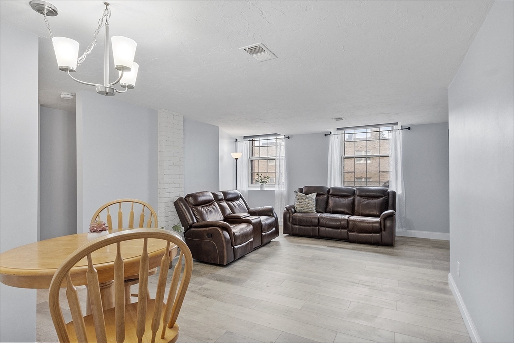 31 Elizabeth Street, Unit G3 Worcester, MA 01605 - Photo 10 of 28 a living room with furniture a couch and chandelier