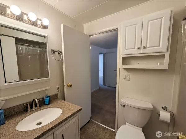 a bathroom with a granite countertop toilet sink and shower
