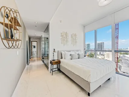 a bedroom with a large bed and a chandelier