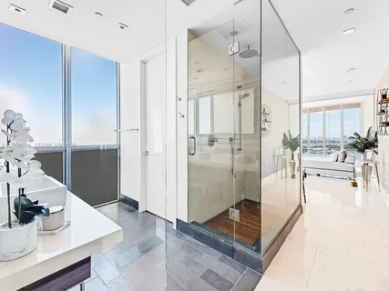 a living room with stainless steel appliances furniture a rug and a view of kitchen