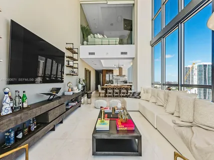a view of living room filled with furniture and flat screen tv