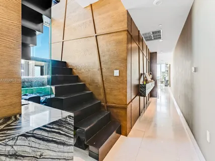 a view of staircase with lots of frames on wall and a potted plant