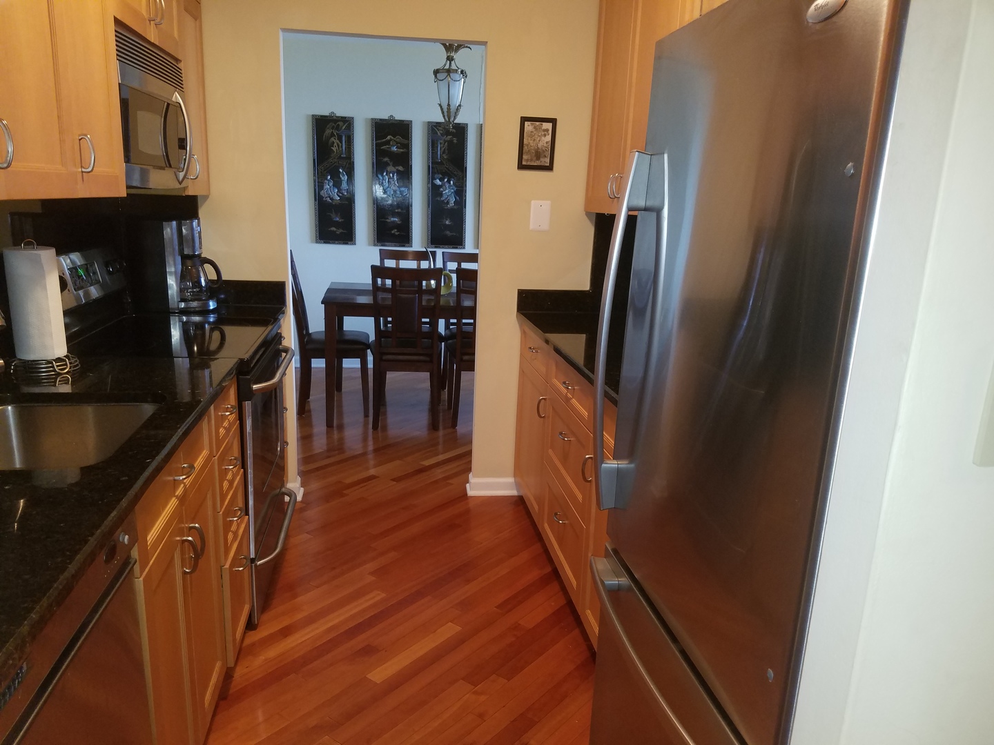 Undisclosed Address Chicago, IL 60613 - Photo 4 of 16 a kitchen with stainless steel appliances a refrigerator a stove a sink a dining table and chairs