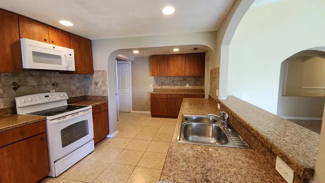a kitchen with stainless steel appliances granite countertop a refrigerator and a stove