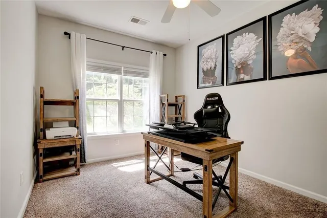 a view of a workspace with furniture and a window