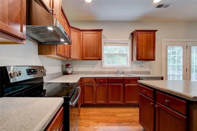 a kitchen with stainless steel appliances granite countertop a sink stove and cabinets