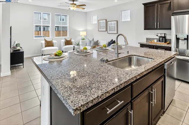 a kitchen with granite countertop a sink a stove and cabinets