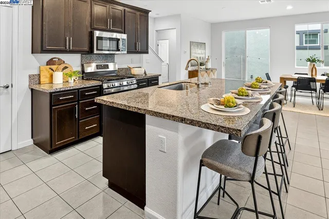 a kitchen with stainless steel appliances granite countertop a stove a sink a microwave and a refrigerator