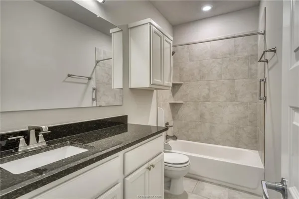 a bathroom with a granite countertop sink toilet and shower
