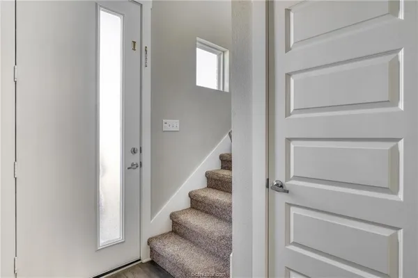 a view of staircase with white walls and railing