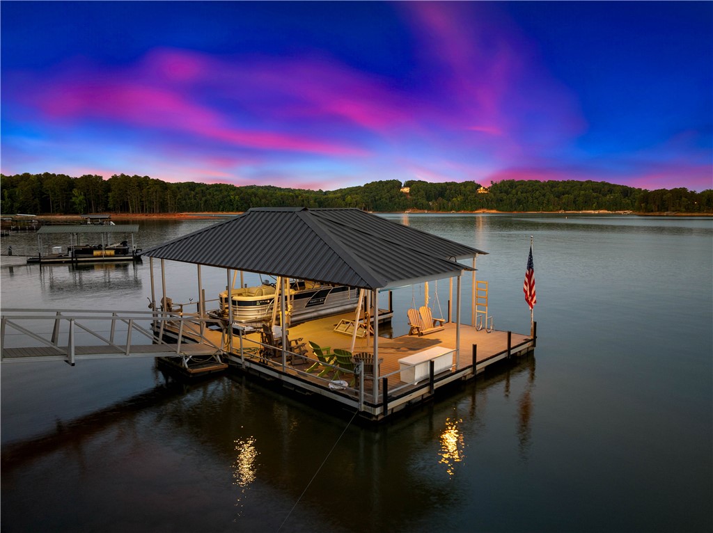 285 Bertha Allen Road Westminster, SC 29693 - Photo 2 of 50 A private covered dock with boat slip, providing direct lake access at sunset.
