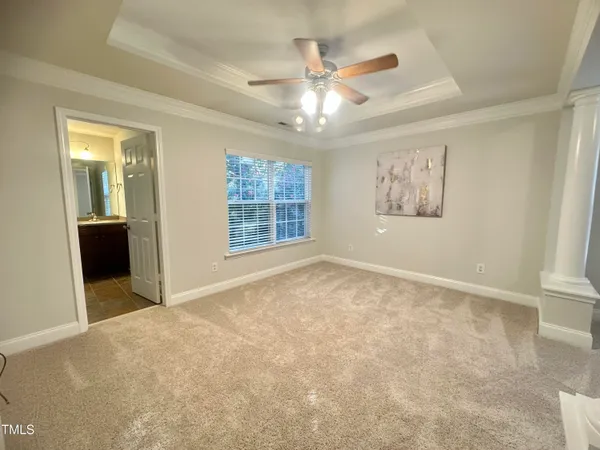 an empty room with windows and ceiling fan