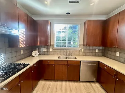 a kitchen with a sink stove and cabinets