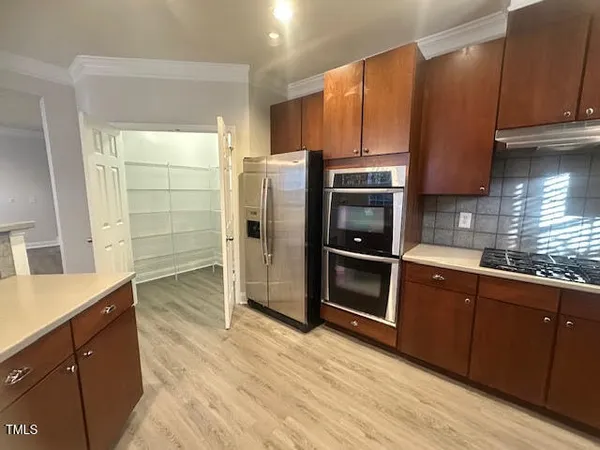 a kitchen with stainless steel appliances wooden cabinets and a refrigerator