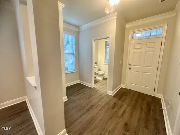 an empty room with wooden floor and entrance