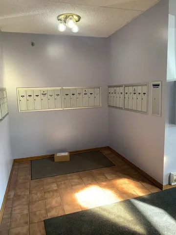 a view of a hallway with wooden floor and chandelier