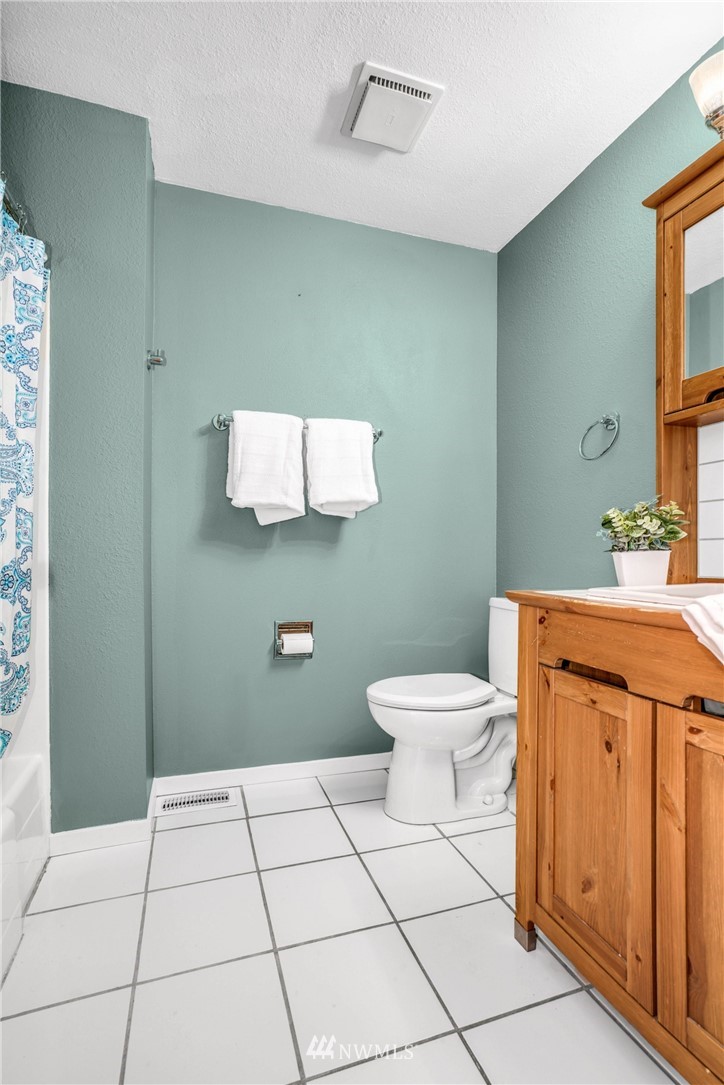 22936 Southeast 288th Street Maple Valley, WA 98038 - Photo 11 of 26 a bathroom with a toilet a sink a mirror and vanity