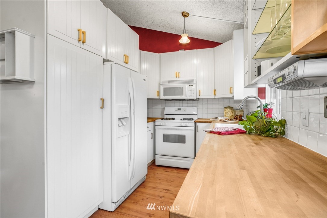 22936 Southeast 288th Street Maple Valley, WA 98038 - Photo 6 of 26 a kitchen with white cabinets and white appliances