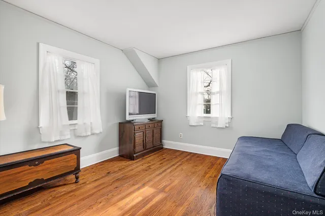 a view of a white house with a small yard and large tree