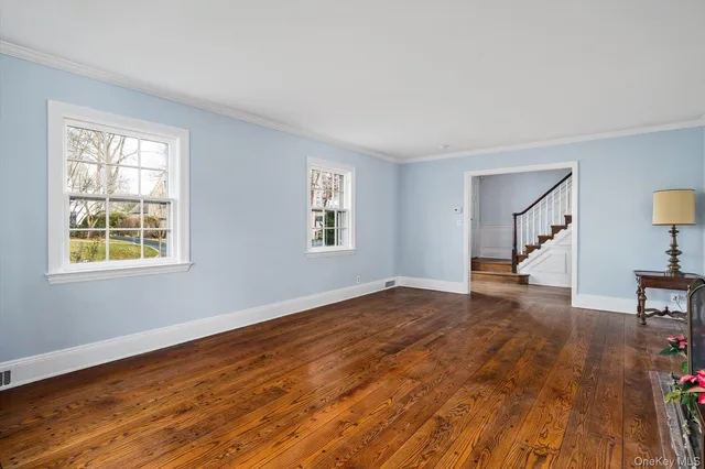 a view of a hallway with wooden floor and dining room