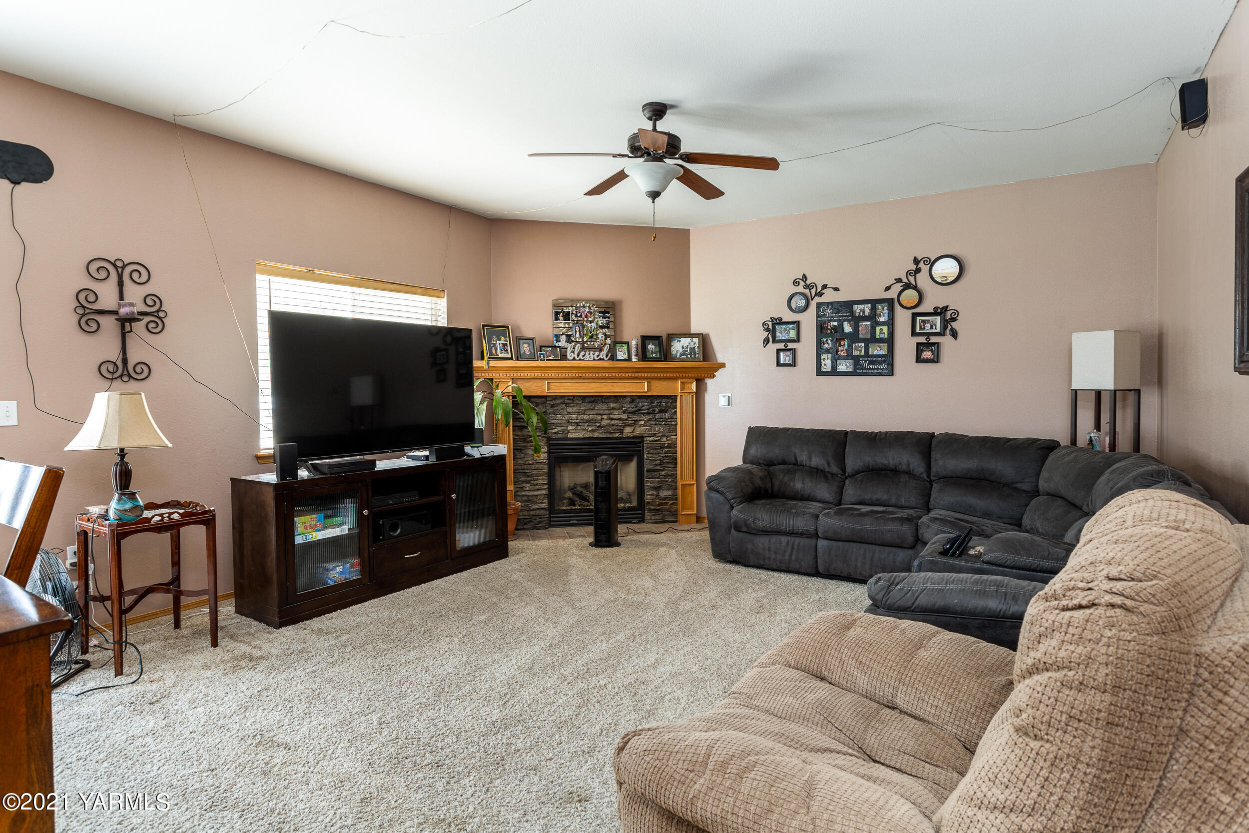 391 Sheep Company Road Selah, WA 98942 - Photo 7 of 26 a living room with furniture a flat screen tv and a fireplace