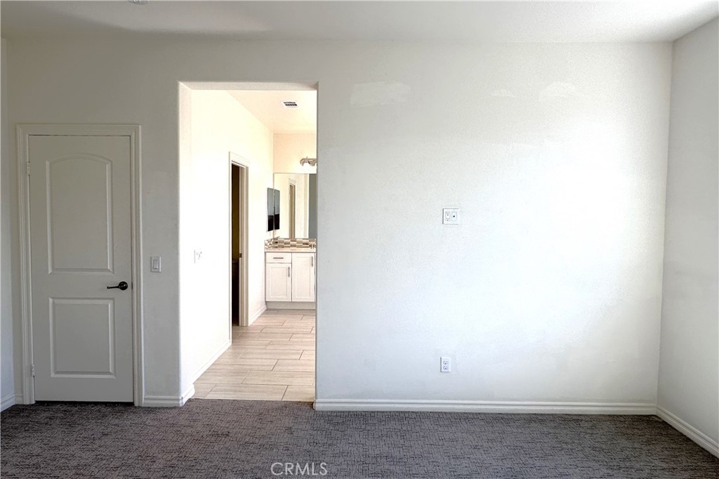 9318 Hellman Avenue, Unit 4 Rancho Cucamonga, CA 91730 - Photo 24 of 28 a view of a hallway with wooden shelves