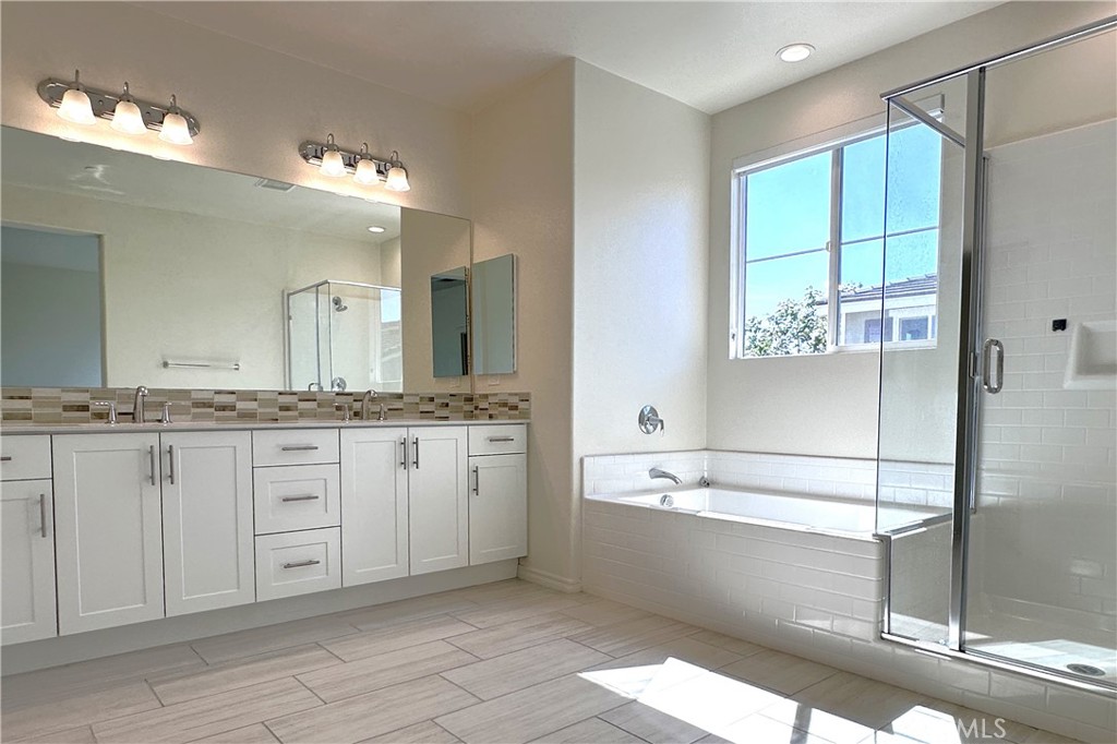 9318 Hellman Avenue, Unit 4 Rancho Cucamonga, CA 91730 - Photo 26 of 28 a spacious bathroom with a granite countertop sink mirror and a bathtub